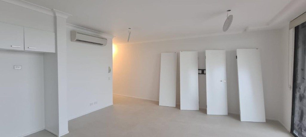 Freshly painted white residential interior with doors ready for hanging